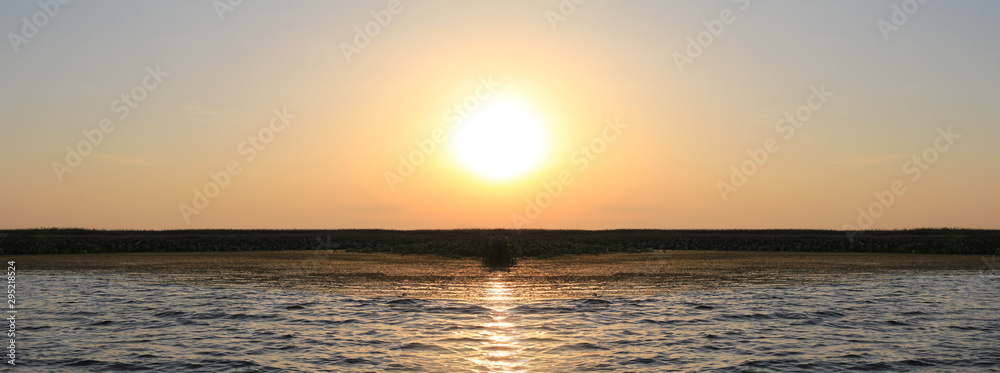 Obraz premium Sunset in the delta of the Volga River on the river Baklanya. The Astrakhan region. Russia. Blurred background.