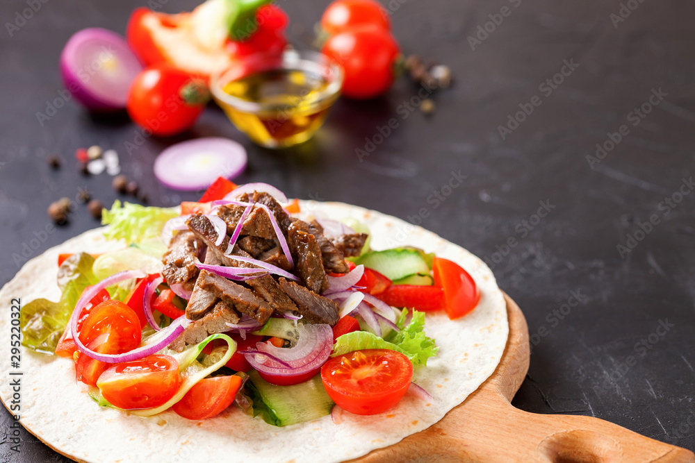 Tacos with Vegetables and Meat against a dark Background. Selective Focus.
