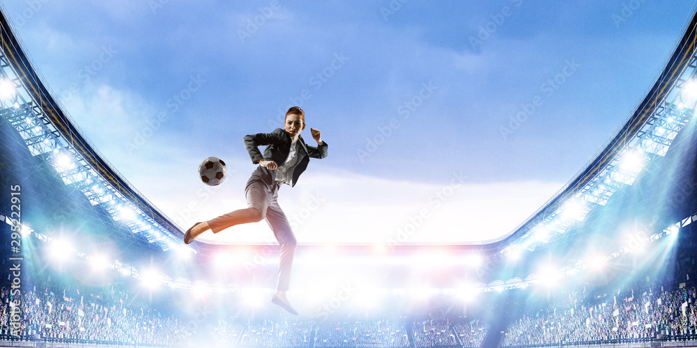 Business woman playing footbal on stadium