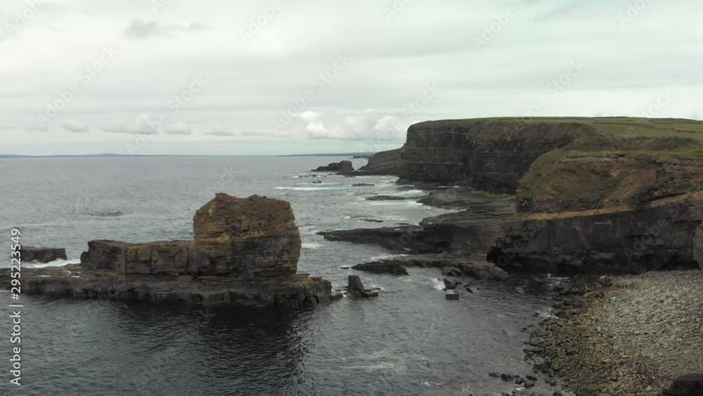 Aerial Flight along the Seashore in Ireland with rocks in the water and waves breaking on them, seagulls flying. Aerial Flight along the Seashore in Ireland with rocks in the water and waves breaking on them, seagulls flying.