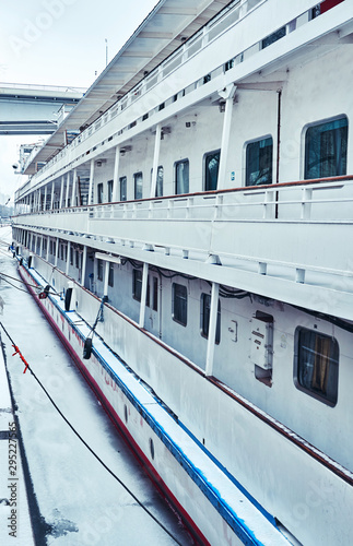 Deck of a white blue moored passenger ship on the embankment with windows to the cabins and stairs © Александр Коновалов