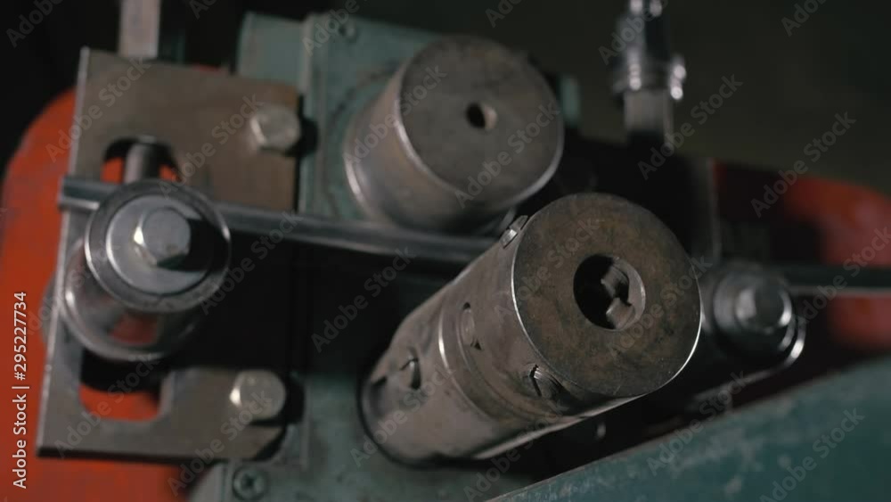Forge workshop on table. Worker bends the metal rod on the wrought iron round bending machine. Manufacturing of a designer part from a metal rod. Forge workshop on table. Worker bends the metal rod on the wrought iron round bending machine. Manufacturing of a designer part from a metal rod.