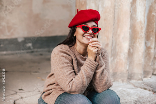 Plus zise model wearing sweater and beret posing on the city street © Alena Ozerova