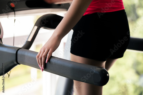 Women running on treadmills in modern and luminous fitness gym