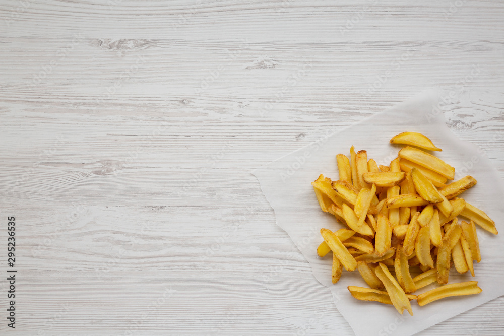 Homemade french fries with salt on a white wooden surface, top view. Flat lay, overhead, from above. Copy space. Homemade french fries with salt on a white wooden surface, top view. Flat lay, overhead, from above. Copy space.