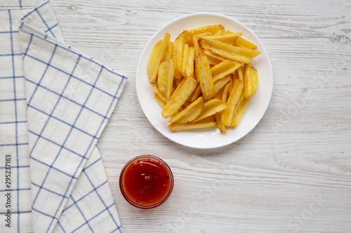 Homemade french fries with sour-sweet sauce on a white plate, top view. Flat lay, overhead, from above. Copy space.