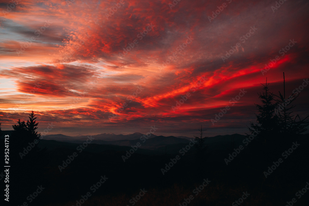 Magical sunset in the mountains. The sky is covered with clouds of red Magical sunset in the mountains. The sky is covered with clouds of red