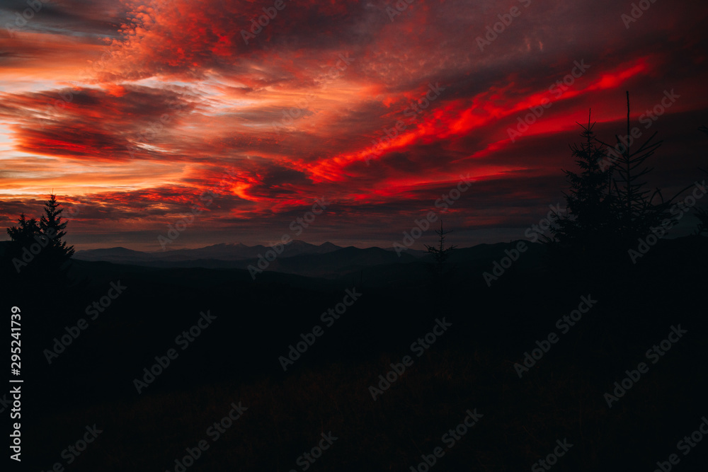 Magical sunset in the mountains. The sky is covered with clouds of red