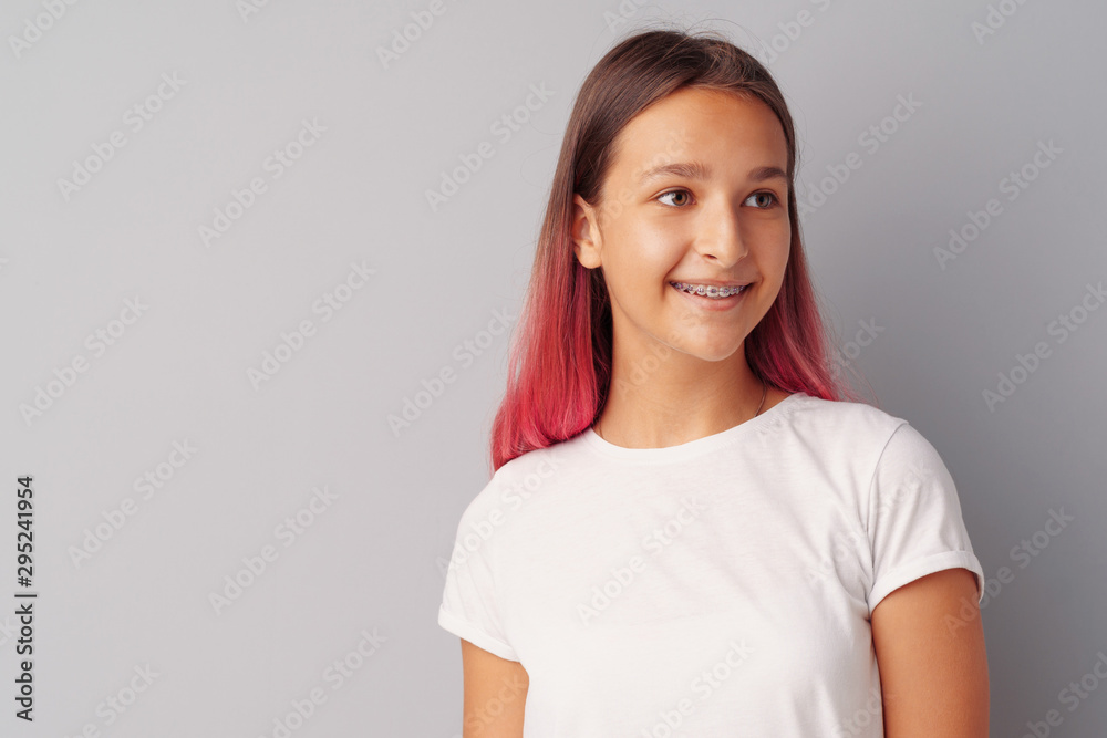 Young girl teenager with pink hair happy and smiling over gray background Young girl teenager with pink hair happy and smiling over gray background