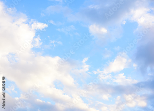 Beautiful pastel colored clouds at sunset isolated against blue skies photo