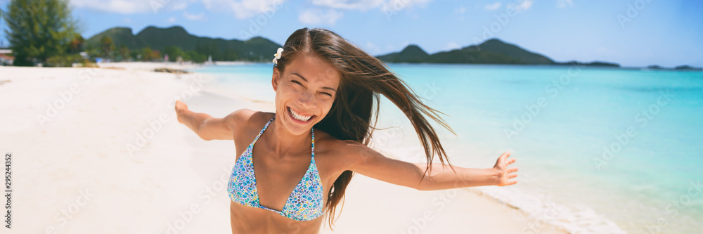 Happy beach vacation woman having fun free with open arms dancing on Caribbean tropical landscape winter travel destination panoramic banner. Asian tourist. Happy beach vacation woman having fun free with open arms dancing on Caribbean tropical landscape winter travel destination panoramic banner. Asian tourist.