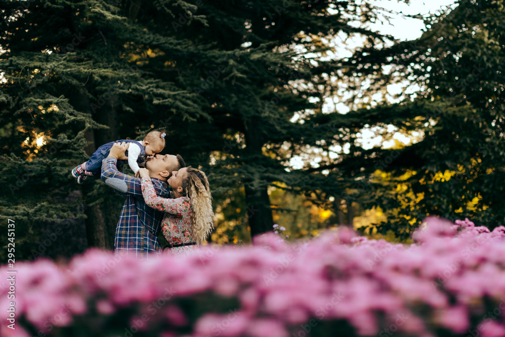 Fototapeta premium Happy family father, mother and child daughter outdoor enjoying sunset - Image