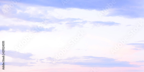 Beautiful pastel colored clouds at sunset isolated against blue skies photo