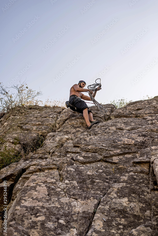 Rock climber climbing up a rock, extreme sport concept.