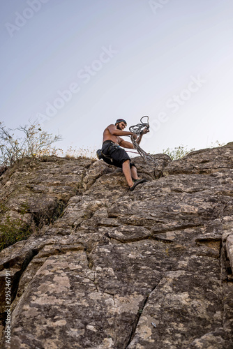Rock climber climbing up a rock  extreme sport concept.