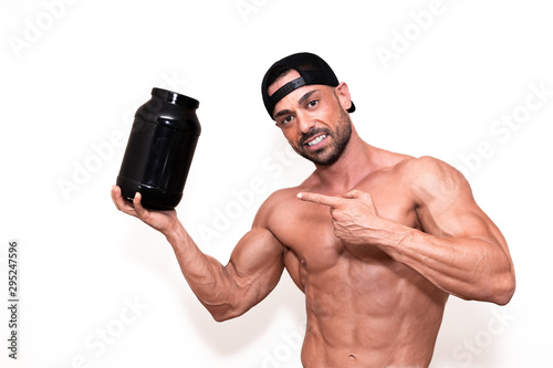 Fitnes model boy pointing a protein container in his hand