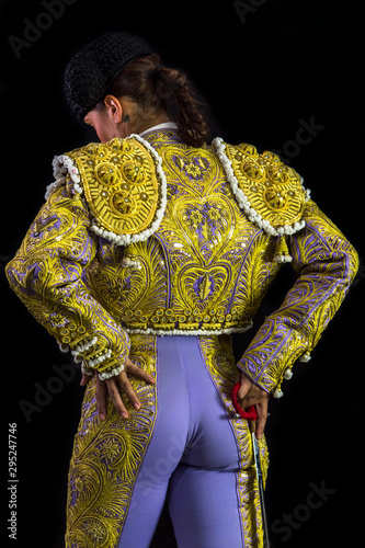 Woman bullfighter posing suit on his back with light purple and gold with sword