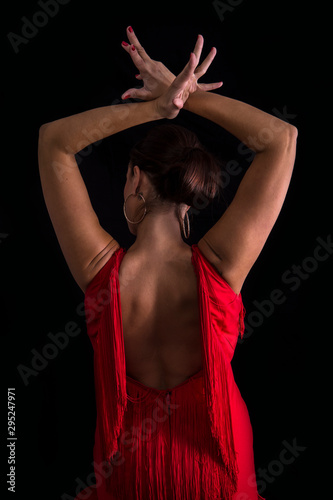 Flamenco dancer on your back with your arms crossed up passionate in black background