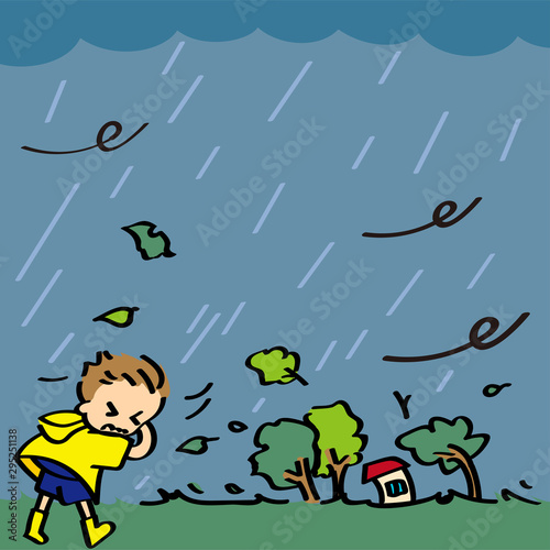 台風、悪天候による暴風の中を歩く男の子