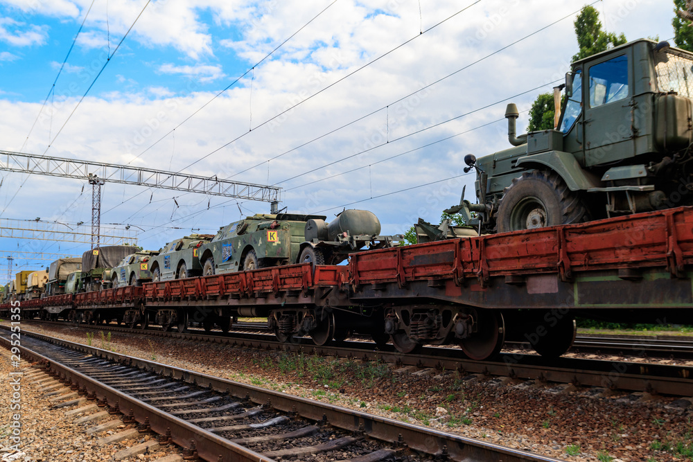 Naklejka premium Cargo train carrying military vehicles on railway flat wagons