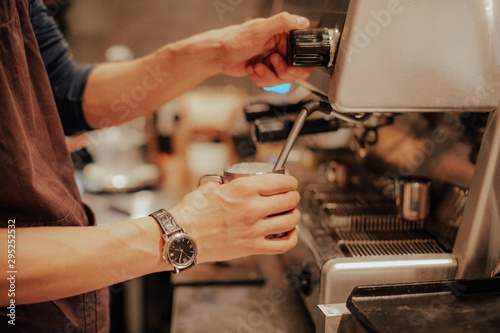 Barista make coffee latte art with espresso machine in cafe vintage instagram filter. Barista male hands make fresh flavored coffee close-up. Vintage coffee machine and hands professional barista.   © Julia