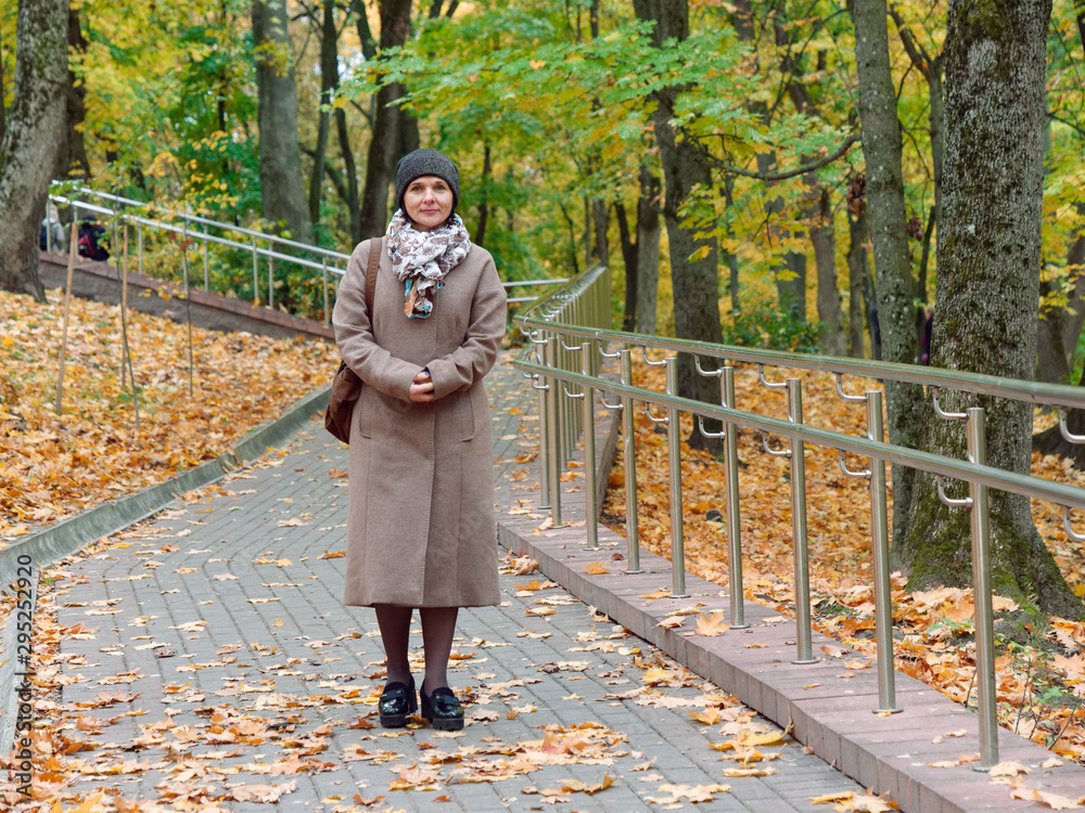 Fototapeta premium Beautiful brunette woman in autumn yellow park