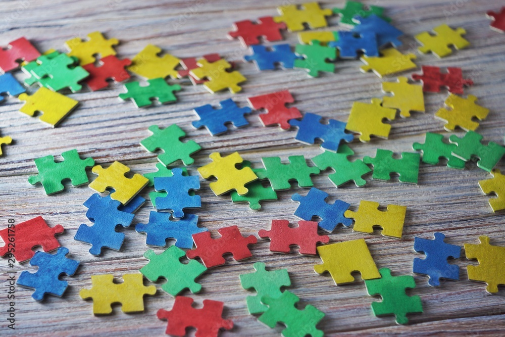 colorful puzzles on a white wooden background, frame, concept of early childhood autism colorful puzzles on a white wooden background, frame, concept of early childhood autism