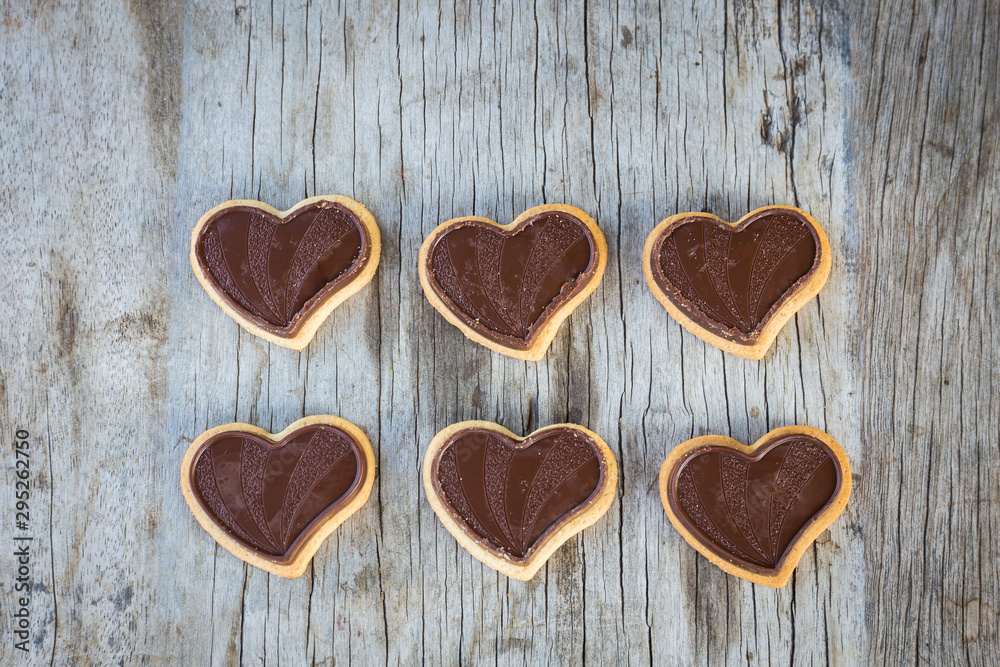 Obraz premium Chocolate heart on wooden background for gift in Valentine's day love. Select focus