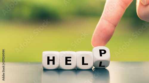 Getting help concept. Hand turns a dice and changes the word "hell" to "help".