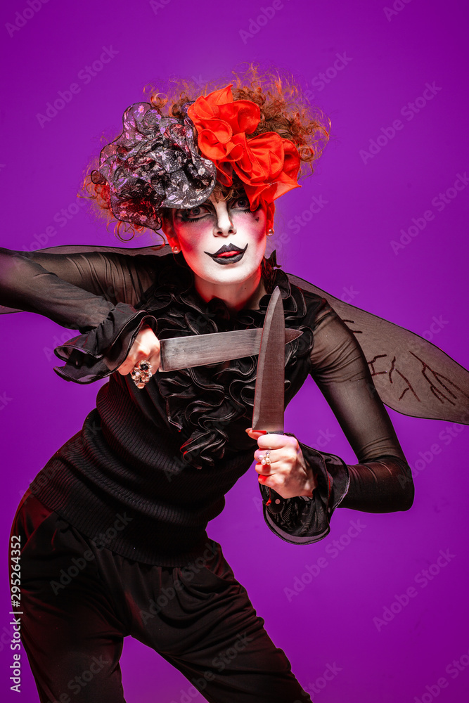 A closeup of a scarier clown female Holding Knife