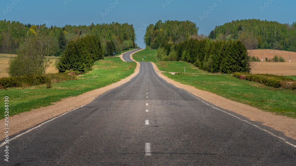 Empty country road vanishing toward horizon 