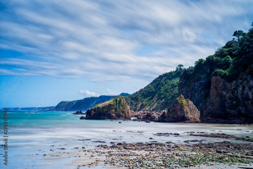 sun and clouds on a beach in Asturias next to its cliffs sun and clouds on a beach in Asturias next to its cliffs