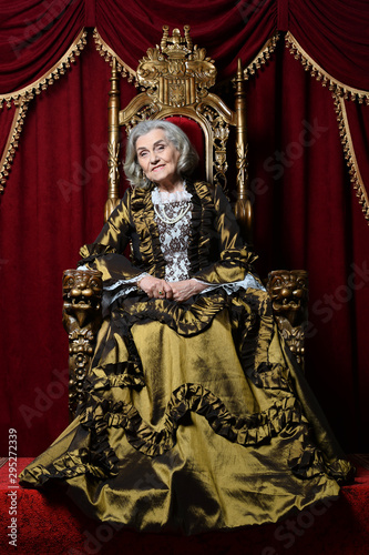 Portrait of a beautiful senior woman Queen on throne