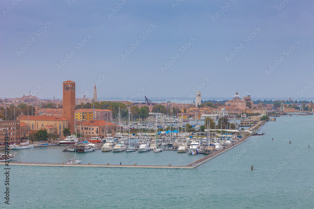 Boats in the marina of the island of Sant'Elena with Venice and big cruise ships outline, Venice, Italy