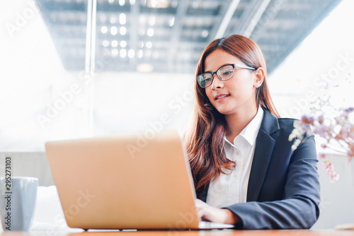 Asian woman working with laptop and coffee in vintage color tone