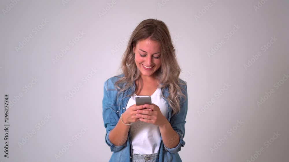 Beautiful blonde woman using smart phone posting on her blog in social media and happy with likes from followers and online business.Isolated on neutral background. In entrepreneur, online networking Beautiful blonde woman using smart phone posting on her blog in social media and happy with likes from followers and online business.Isolated on neutral background. In entrepreneur, online networking