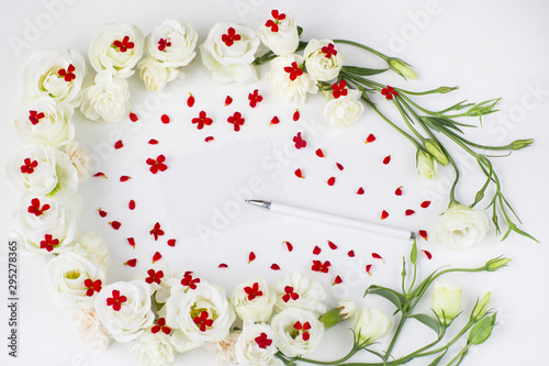Fototapeta Naklejka Na Ścianę i Meble -  white flowers and red flowers and a sheet of paper, pen