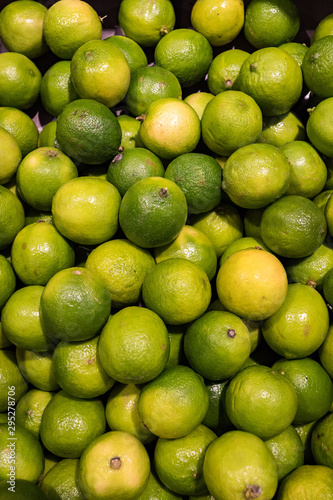 Looking down on pile of vibrant green limes in a grocery store
