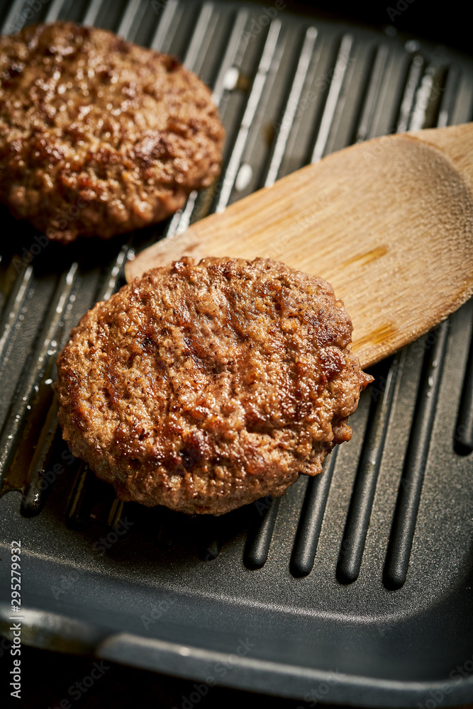 Closeup of juicy burgers fried on black grill pan Closeup of juicy burgers fried on black grill pan
