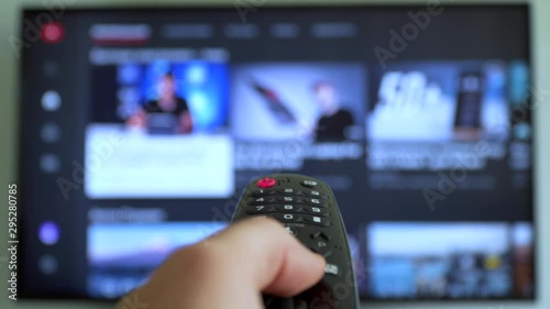 Internet online cinema smart tv Channel surfing. hand holding the TV remote control smart television photo