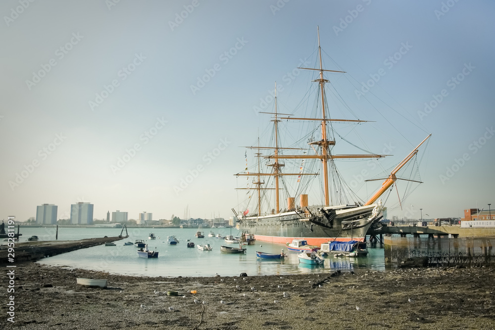PortsmHMS Warrior, the first iron-clad battleship launched by the British Royal in 1860, now a floating museum moored in Portsmouth Harbour, UK PortsmHMS Warrior, the first iron-clad battleship launched by the British Royal in 1860, now a floating museum moored in Portsmouth Harbour, UK