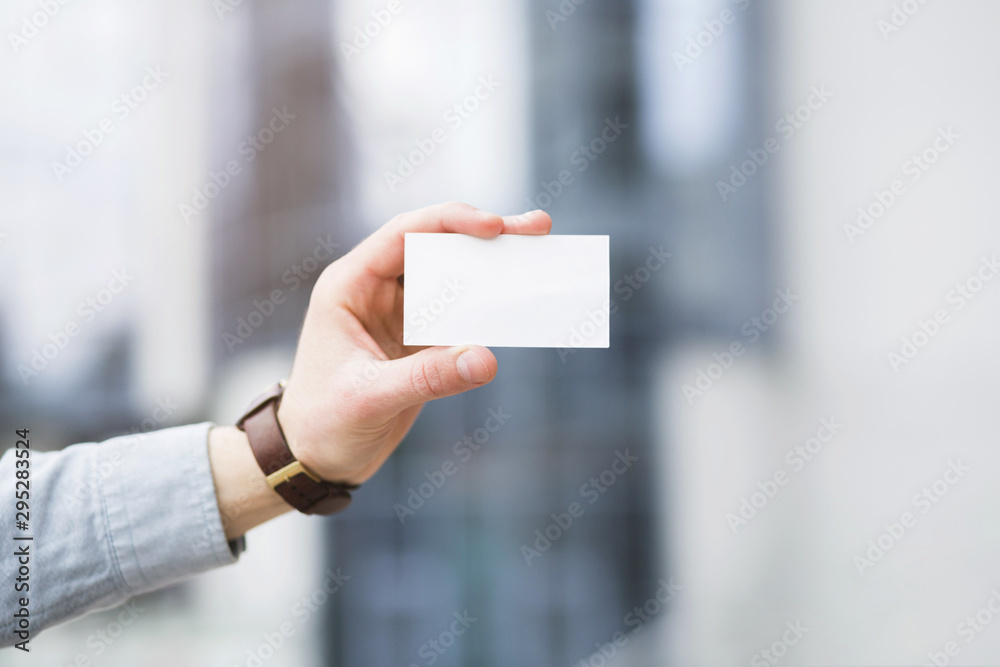 Businessman's hand showing white blank visiting card Businessman's hand showing white blank visiting card