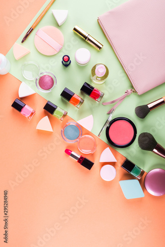 Make up accessories on orange cantaloupe and mint green background. Beauty products colorful fashion flat lay