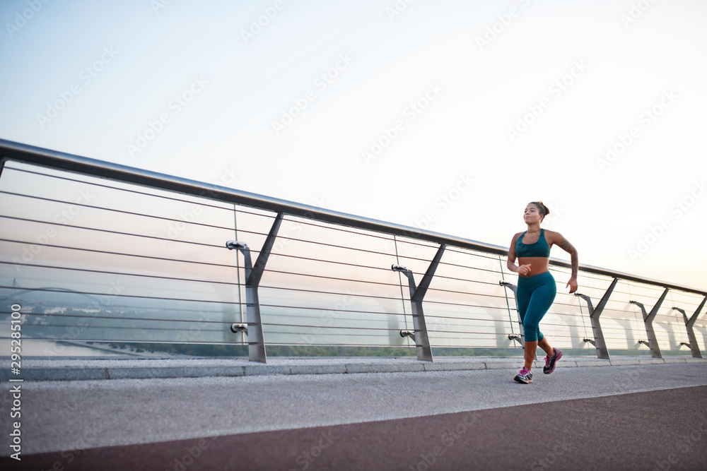 Overweight dark-skinned woman running in the morning