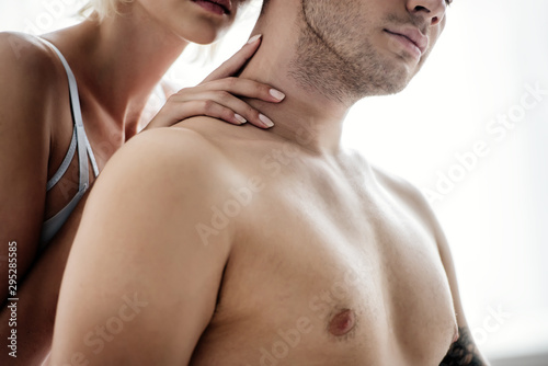 cropped view of woman hugging shirtless man in apartment