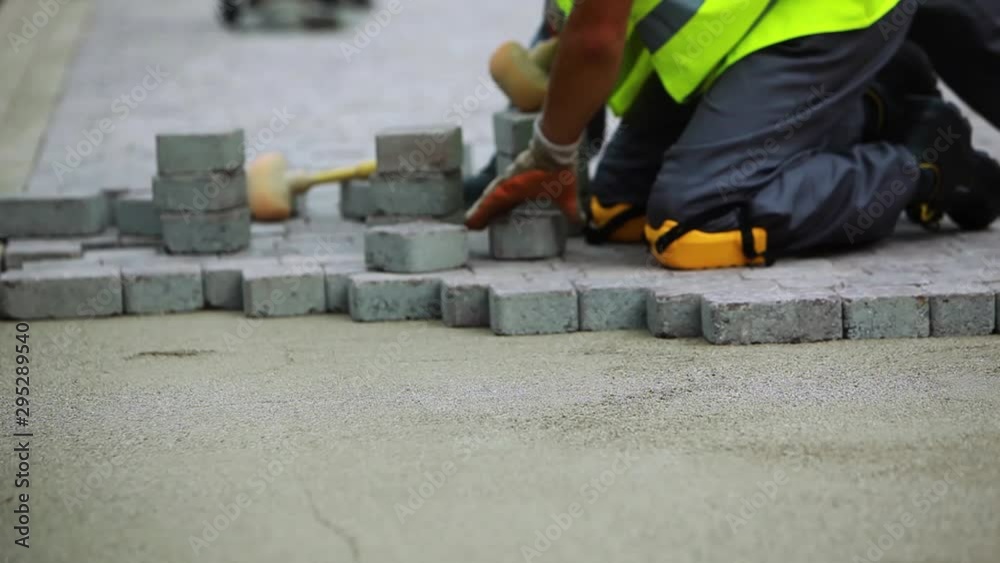 Stone Pavement Road Construction Workers Wearing Knee Protection. Fitting stone tiles