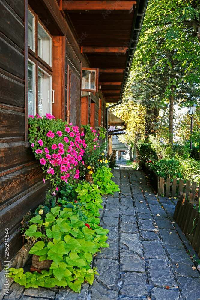 LANCKORONA, POLAND - SEPTEMBER 05, 2019: Stone path along the wooden cottages LANCKORONA, POLAND - SEPTEMBER 05, 2019: Stone path along the wooden cottages