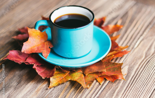 Autumn composition, autumn leaves and a cup of coffee on a wooden background. Flat position, top view, copy space