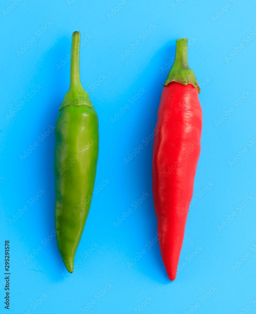 Green and red chili peppers on a blue background Green and red chili peppers on a blue background