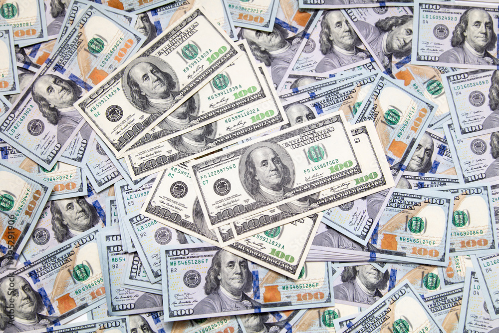 One hundred dollar bills on the table as background One hundred dollar bills on the table as background
